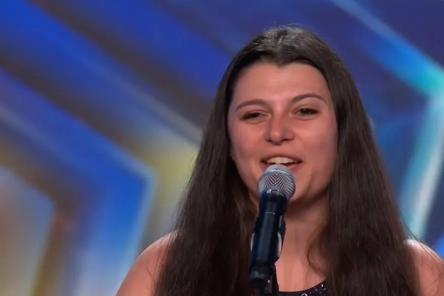 Kimberly Winter smiling at the microphone on the Britain's Got Talent stage