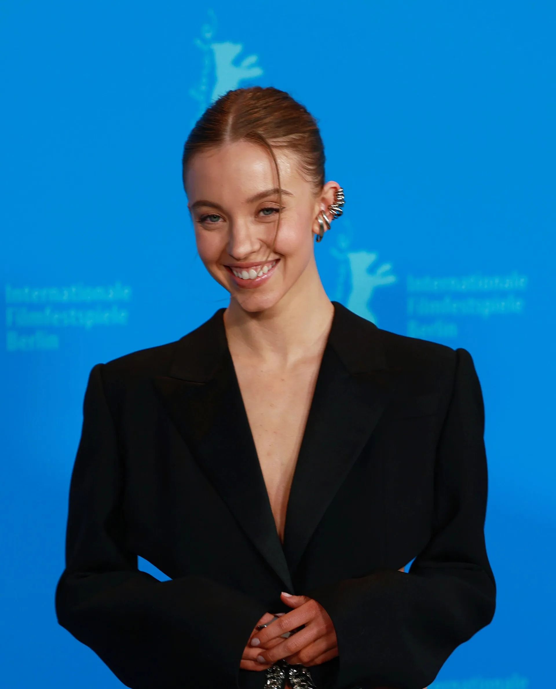 Sydney Sweeney smiling in a black blazer at the Berlinale photocall