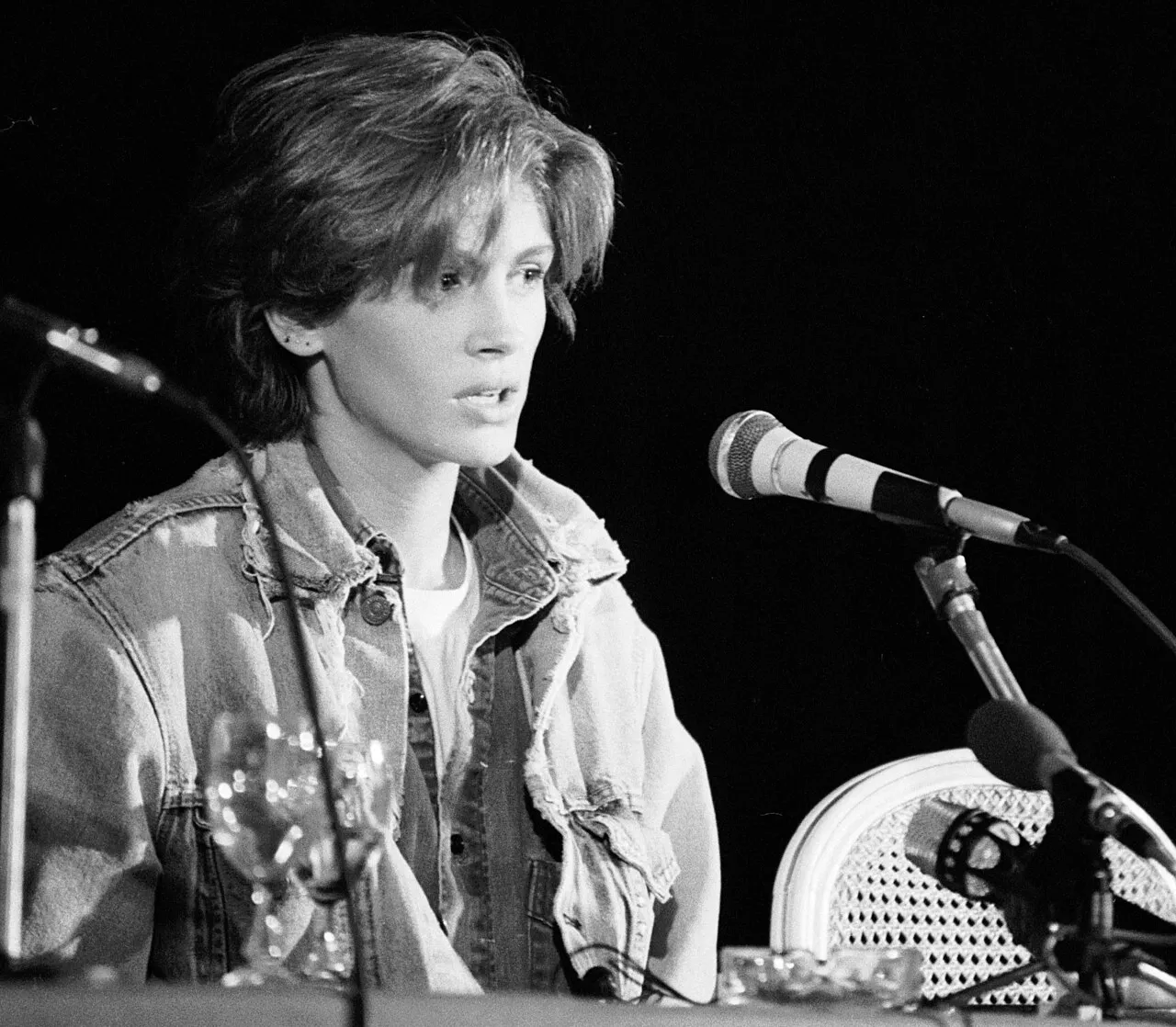 Black-and-white photo of Julia Roberts at a press conference in a denim jacket
